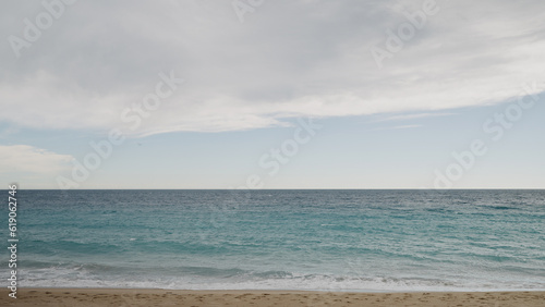 Clear blue waves with strong wind on a sandy empty beach in Cannes in spring