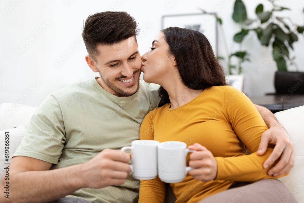 Cheerful loving hispanic man and woman drinking tea together, cuddling Cheerful loving hispanic man and woman drinking tea together, cuddling