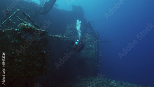 Scuba diver swim along hull of ferry Salem Express shipwreck, Back view, Red sea, Safaga, Egypt