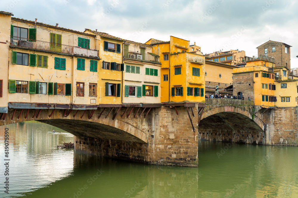 A picturesque view of Ponte Vecchio, the oldest bridge in Florence, with the River Arno flowing beneath it