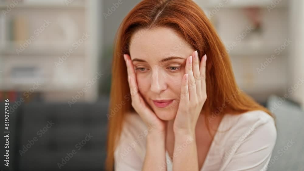 Young redhead woman stressed sitting on sofa at home Young redhead woman stressed sitting on sofa at home