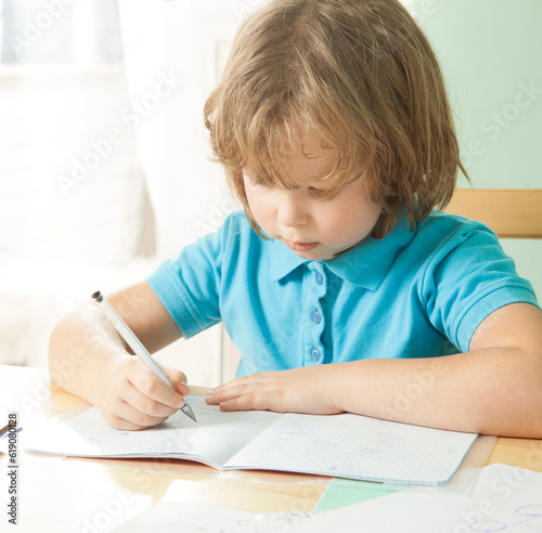 Little boy is doing his homework for elementary school