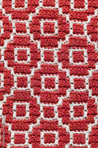 Abstract seamless crochet fabric. Mosaic crochet pattern. Red white knitted background.