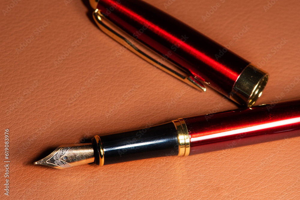 Fountain pen, beautiful details of a fountain pen on a leather surface, selective focus. Fountain pen, beautiful details of a fountain pen on a leather surface, selective focus.
