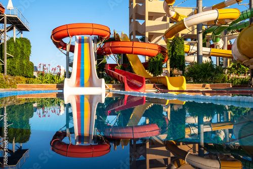 Empty Water park for kids in a luxury hotel near the sea. Water park, bright multi-colored slides with a pool. A water park without people on a summer day with a beautiful, cloudy blue sky. Aquapark 