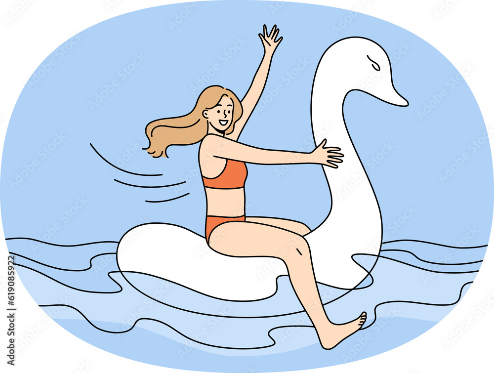 Happy girl in swimsuit float on rubber swan Happy girl in swimsuit float on rubber swan