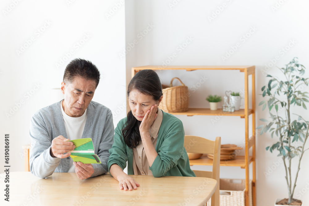 通帳を見るシニア夫婦 通帳を見るシニア夫婦