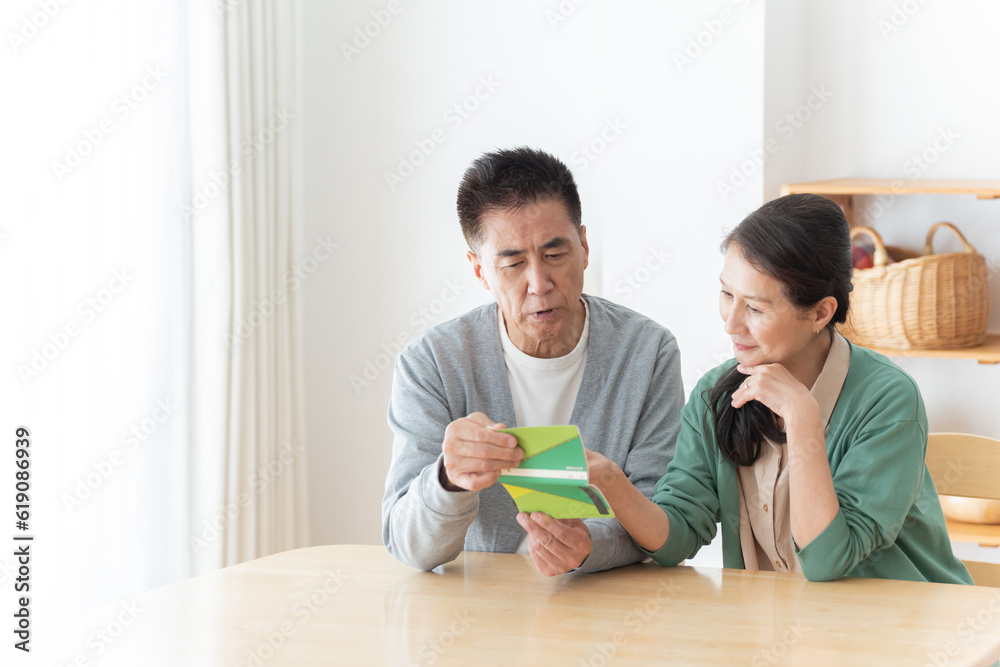 通帳を見るシニア夫婦 通帳を見るシニア夫婦