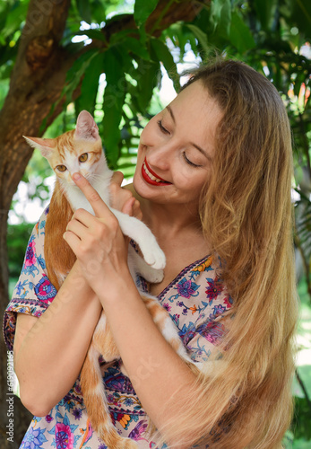 Young blond woman hugging her red cat