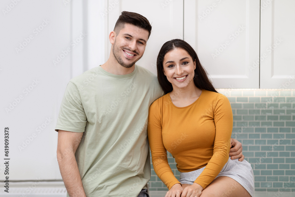 Portrait of happy beautiful young couple posing at kitchen Portrait of happy beautiful young couple posing at kitchen