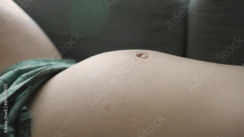 Close-up of pregnant woman with baby moving and kicking inside belly