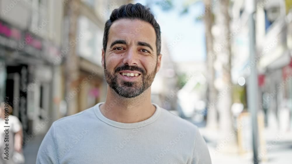 Young hispanic man smiling confident standing at street