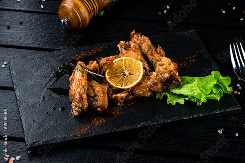 Fried duck wings and legs with lemon, lettuce and microgreens.
