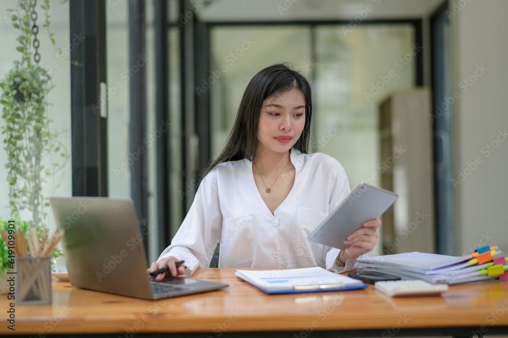 Young businesswoman working diligently, focus on working in front of the laptop. Analyze and plan new projects. Young businesswoman working diligently, focus on working in front of the laptop. Analyze and plan new projects.