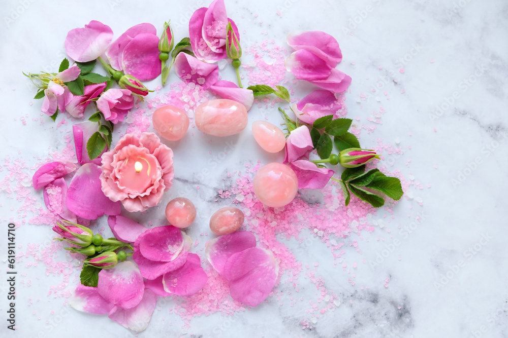 set of Rose quartz crystals, flower candle, sea salt and wild rose flowers and petals on marble background. Healing Crystals For Body Care, Relationship, Self care. meditation ritual. top view