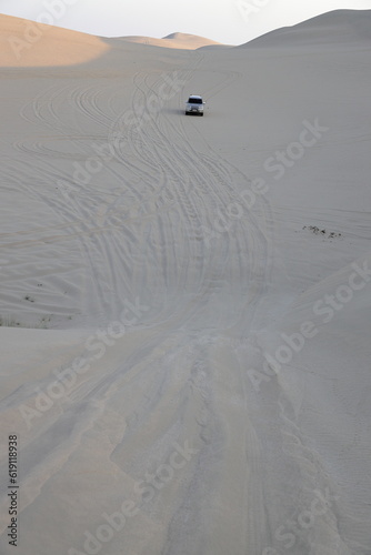 Obraz na plátně Enthusiasts in Qatar drive to sand dunes in their SUV during weekends