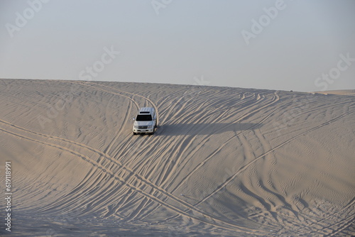 Fototapeta Naklejka Na Ścianę i Meble -  Enthusiasts in Qatar drive to sand dunes in their SUV during weekends.  Dune bashing is a great leisure time sport in Qatar. 