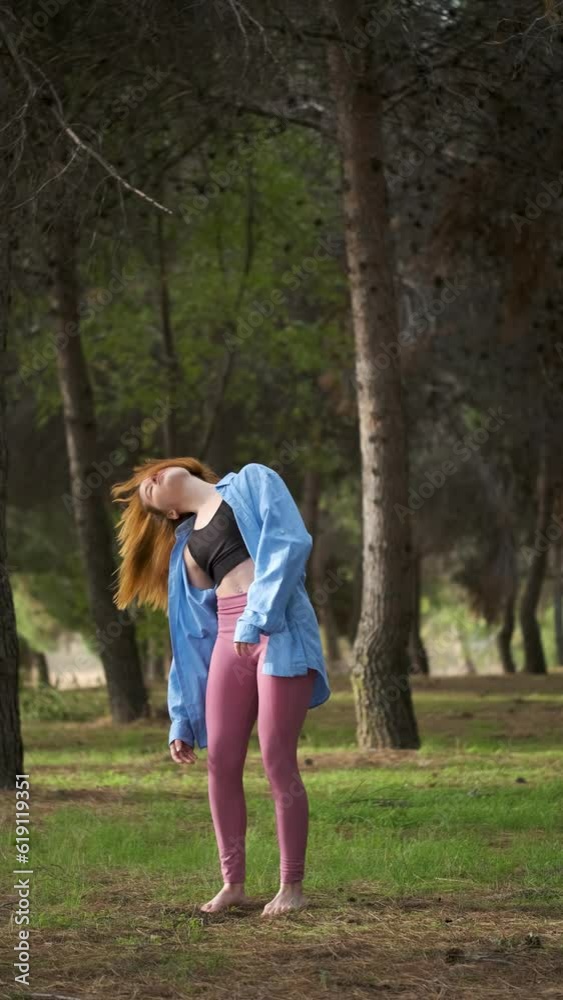 Redhead young woman practicing contemporary dance in a forest. Dancer in nature. Redhead young woman practicing contemporary dance in a forest. Dancer in nature.