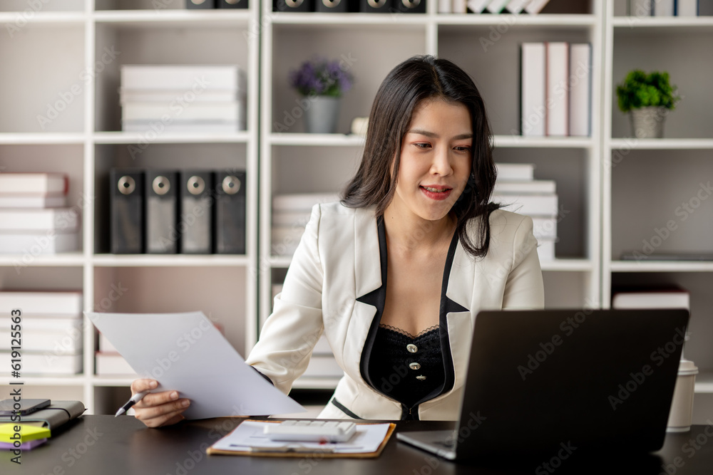 Young beautiful asian woman working in corporate office, businesswoman working in office attentively to grow and modernize start-up business, she is analyzing company's market and financial data. Young beautiful asian woman working in corporate office, businesswoman working in office attentively to grow and modernize start-up business, she is analyzing company's market and financial data.