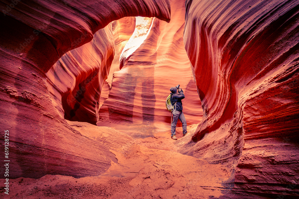 Woman is photographing the incredible sand stone formations build by flash floods at antelope canyon, Utah USA  - obrazy, fototapety, plakaty 
