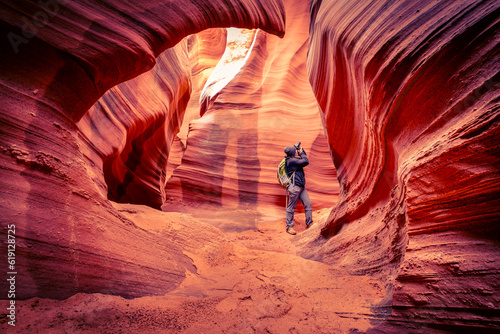 Woman is photographing the incredible sand stone formations build by flash floods at antelope canyon, Utah USA 