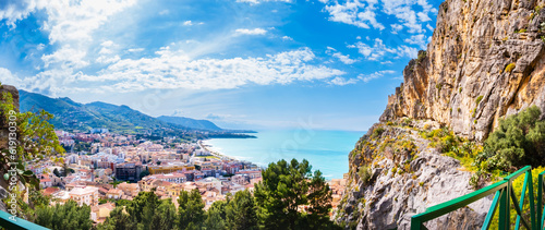 Aerial view of Cefalu, medieval town on Sicily island, Italy. Seashore village with sandy beach, surrounted with mountains. Popular tourist attraction in Province of Palermo