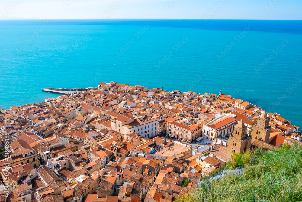 Aerial view of Cefalu old town on Sicily island, Italy. Medieval seashore village with historic buildings, cathedral and sea water. Popular tourist attraction in Province of Palermo