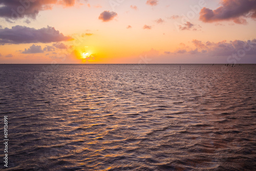 himmel mit sonnenuntergang am meer bei steigender tide  wattenmeer bei flut mit pink bis lila und orange gef  rbten wolken  maritime abendstimmung in cuxhaven duhnen