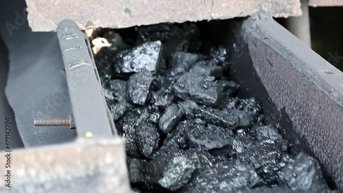 Closeup of charcoal or bituminous coal moving on a roller belt conveyor machine photo