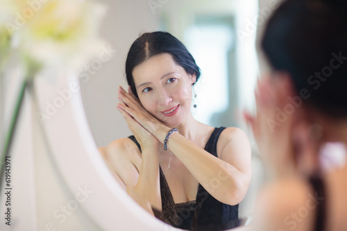 Young Asian woman looking in the mirror.
