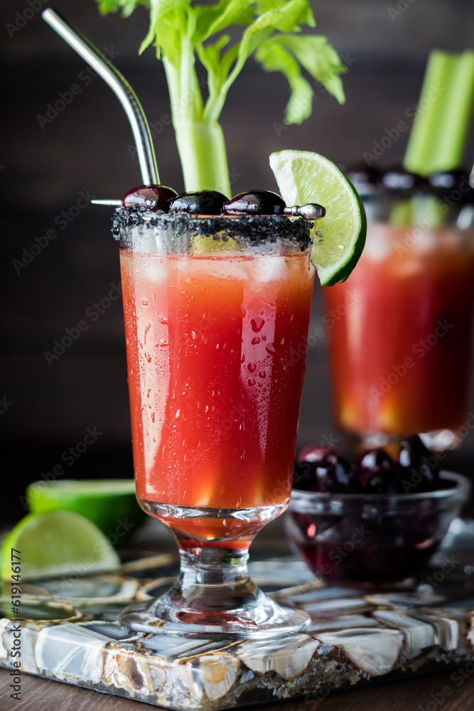 Cold refreshing Caesar cocktails garnished with black olives, lime and celery.