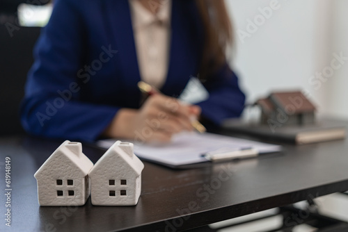 A real estate agent who works at a desk with documents in the office in the hands of a businesswoman, calculates interest, taxes and profits to invest in real estate and buying a house.