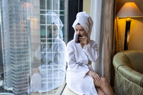 Εκτύπωση καμβά Young woman drinking morning coffee, wearing bathrobe and towel on the head, loo