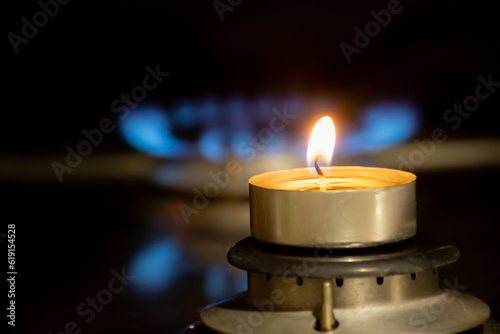 A candle on a gas burner against the background of a flame