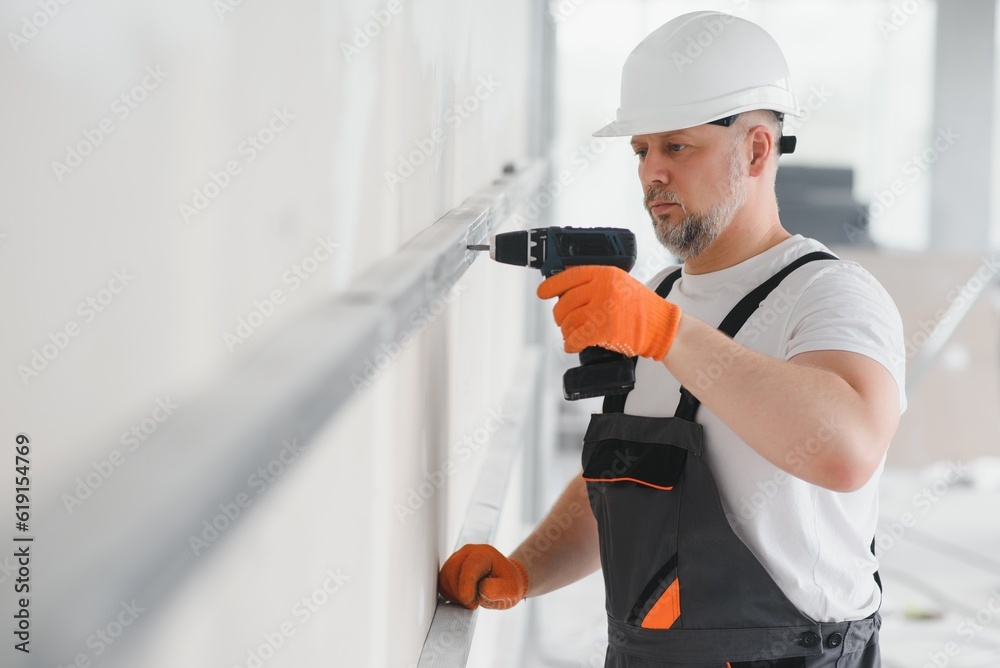 man fasten metal profile frame to the wall for draywall bulkhead. man fasten metal profile frame to the wall for draywall bulkhead.