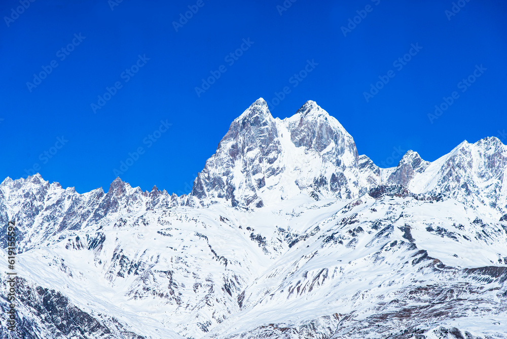 Beautiful panoramic view Ushba peak in Caucasus mountains covered with snow in winter and blue sky in Mestia Svaneti Georgia
