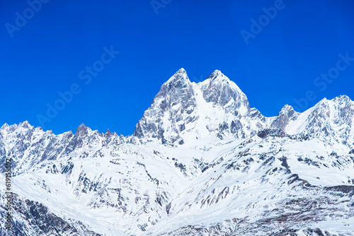 Beautiful panoramic view Ushba peak in Caucasus mountains covered with snow in winter and blue sky in Mestia Svaneti Georgia © Arunporn