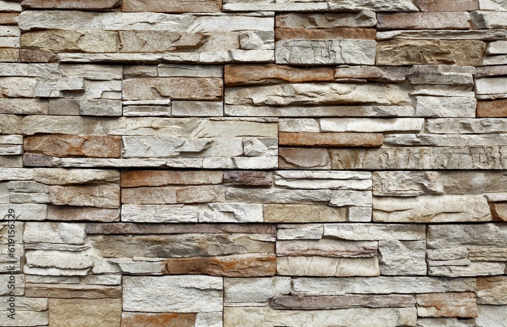 Stone cladding wall made of striped stacked slabs of gray and brown rocks. Panels for exterior. Background and texture. Stone cladding wall made of striped stacked slabs of gray and brown rocks. Panels for exterior. Background and texture.