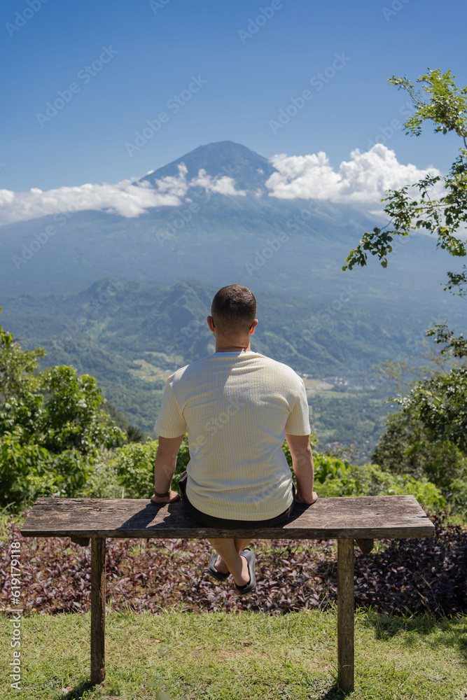 man looking at Agung volcano in Indonesia, Bali island , beautiful landscape of volcano.