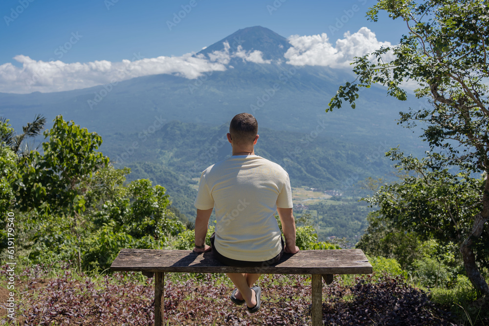 man looking at Agung volcano in Indonesia, Bali island , beautiful landscape of volcano.