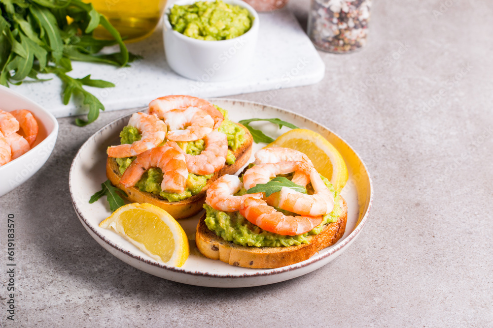 Shrimps on toast with avocado and lemon. Breakfast concept. Bruschetta. Shrimps on toast with avocado and lemon. Breakfast concept. Bruschetta.