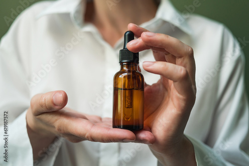 Wallpaper Mural Essential oil with a pipette in the hands of a woman with space to copy. Women's hands with a bottle of oil and a pipette - the sphere of beauty Torontodigital.ca