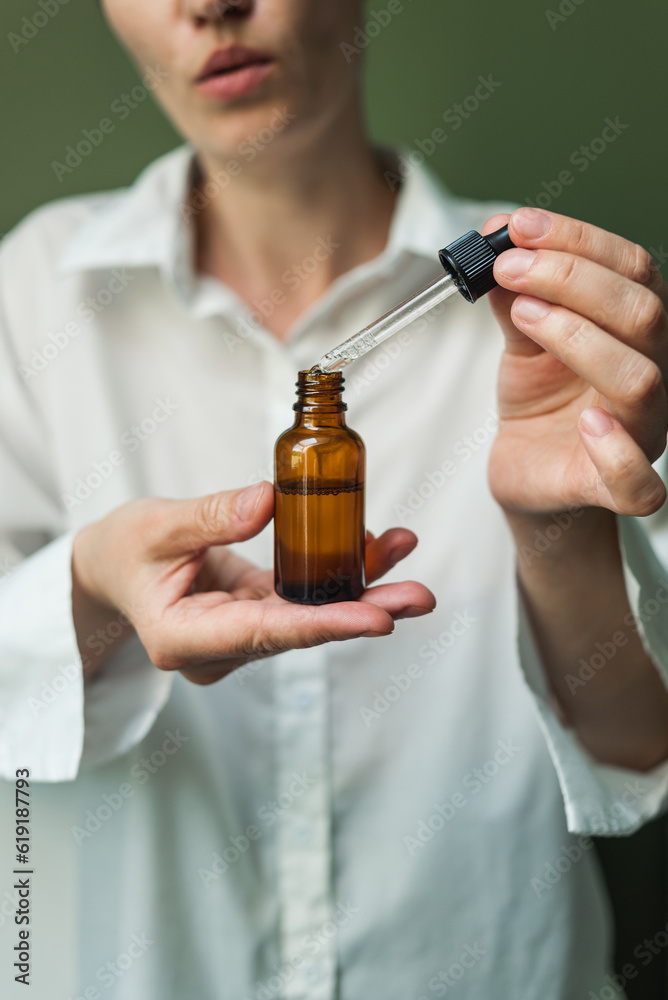 Essential oil with a pipette in the hands of a woman with space to copy. Women's hands with a bottle of oil and a pipette - the sphere of beauty Essential oil with a pipette in the hands of a woman with space to copy. Women's hands with a bottle of oil and a pipette - the sphere of beauty