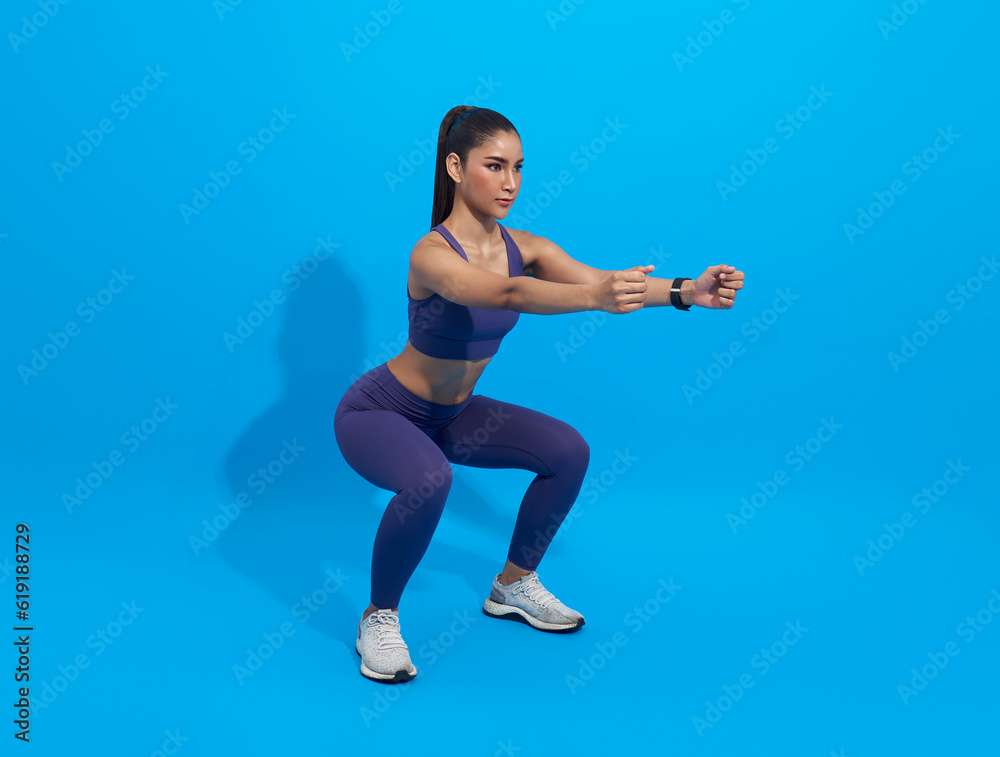Workout. young asian woman doing squat exercise isolated on blue studio fitness gym Background. Workout. young asian woman doing squat exercise isolated on blue studio fitness gym Background.