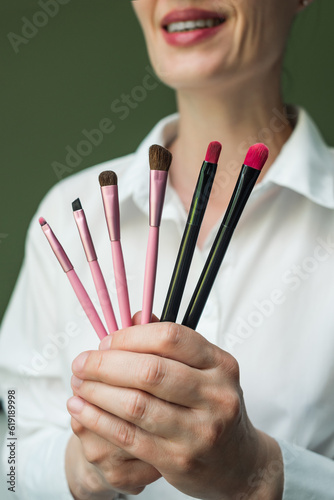 A European woman holds a set of makeup brushes in her hands. A set of makeup brushes in your hands. Makeup artist