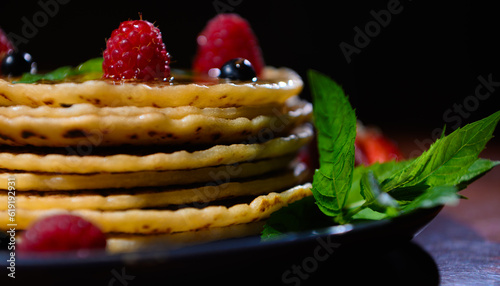 Close-up food background with pancakes decorated with berries and mint leaves for Shrovetide. Still life Selective focus