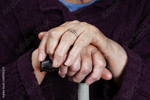 Hands of an elderly woman on a cane