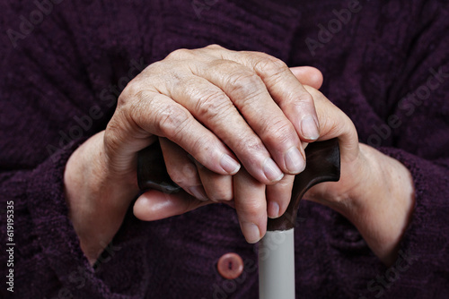 Hands of an elderly woman on a cane