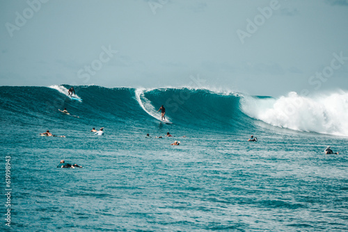 Two Surfer girls on long boards on perfect blue aquamarine wave together, party wave, empty line up, perfect for surfing, clean water, Indian Ocean, Maldives