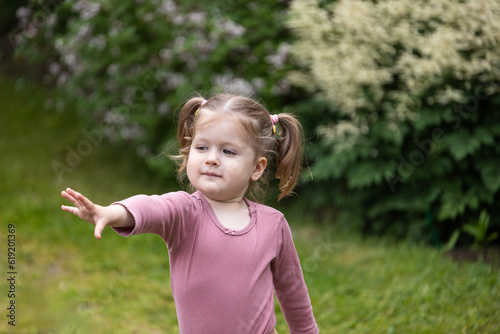 toddler girl stretches her hand out for something  children curiosity  outdoor fun